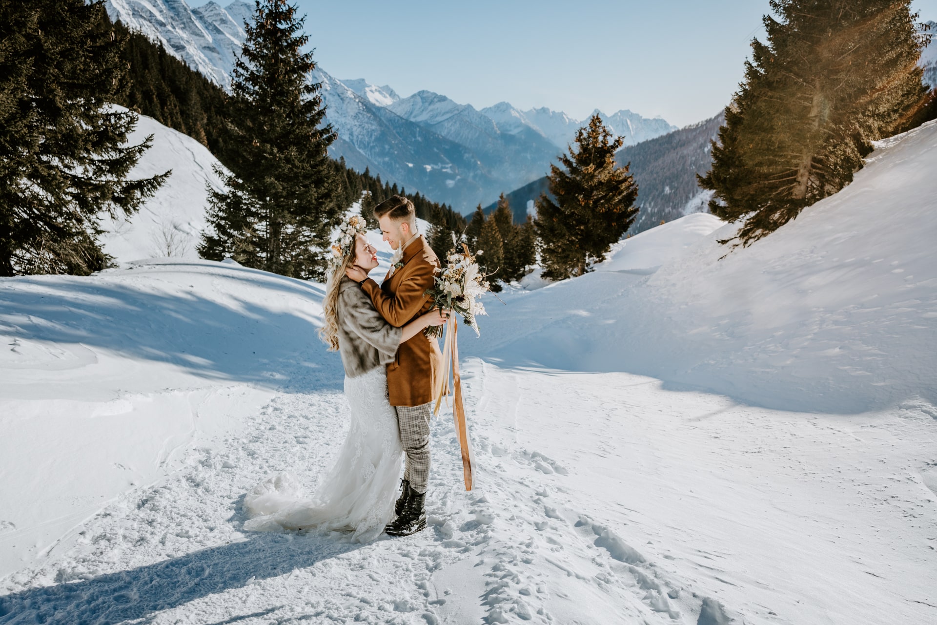 Hochzeitspaar lacht und umarmt sich in den Schweizer Bergen